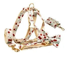 Red cherry print dog collar and leash set with light gold buckle, matching vest, bow, and poop bag holder.