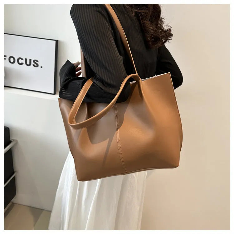 Casual messenger bag in PU leather with stitched detail, bucket shape, double shoulder straps, available in black brown coffee white