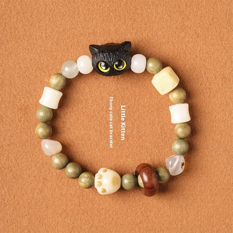 Hand-woven multi-treasure bracelet with Bodhi seeds, jade, and wood beads featuring a cat's paw charm.