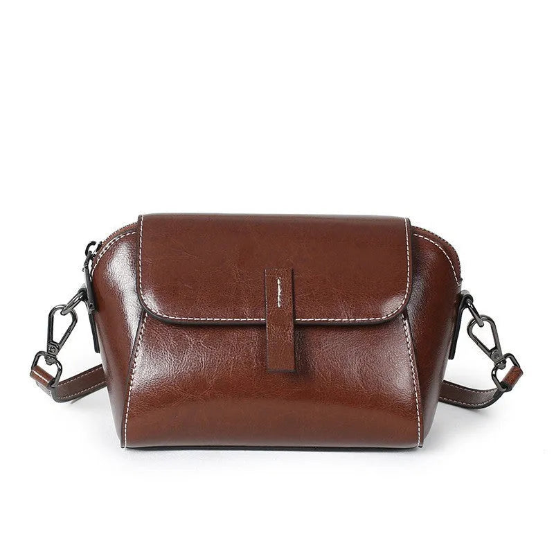 Brown oil wax leather women's messenger bag with cross-body strap showing shell shape and interior compartments