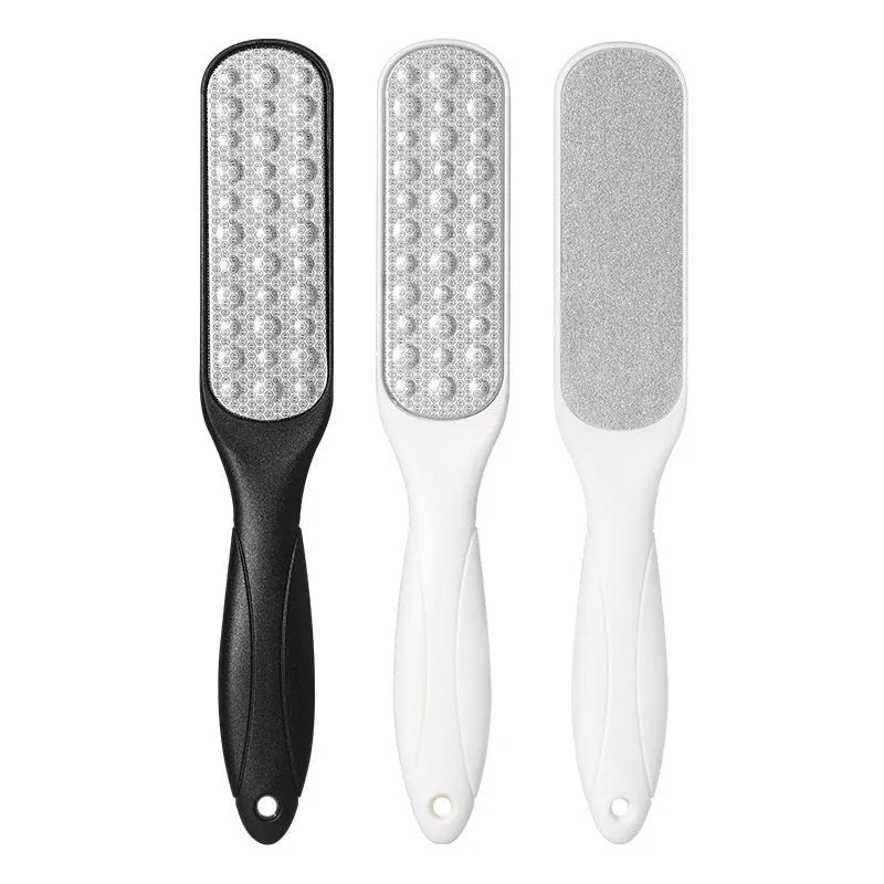 Double-sided stainless steel foot grinder with white and black sandpaper surfaces for callus removal