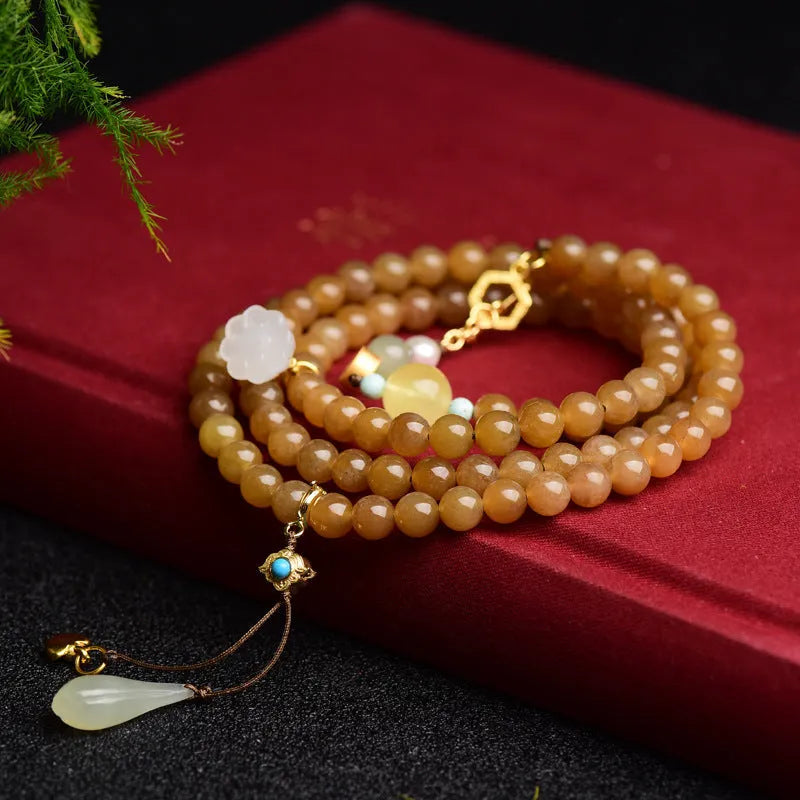 Close-up of a green jade bead bracelet with leaf sequins and a beeswax sheen.