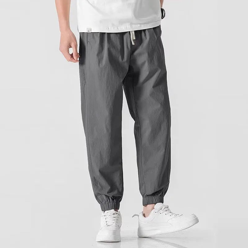 Men's loose cuffed cargo pants in black polyester fabric with cuffed hem and relaxed fit