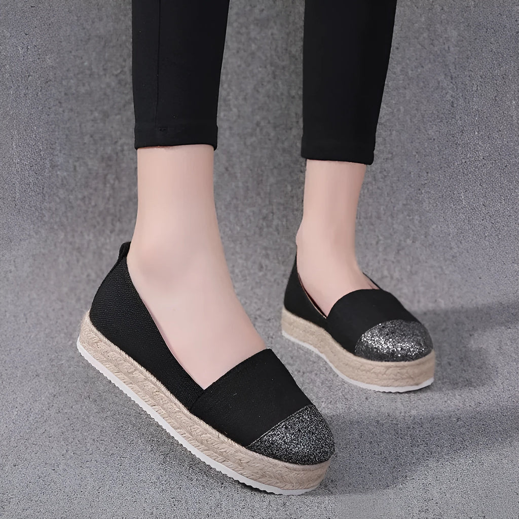 Women's plus size black canvas slip-on flat shoes with round toe, shown from the side.