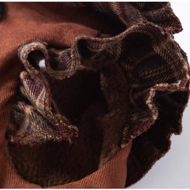 Fleece-lined brown plaid pet sweater dress with ruffle trim on a small dog, showing stretchable knit and skirt silhouette