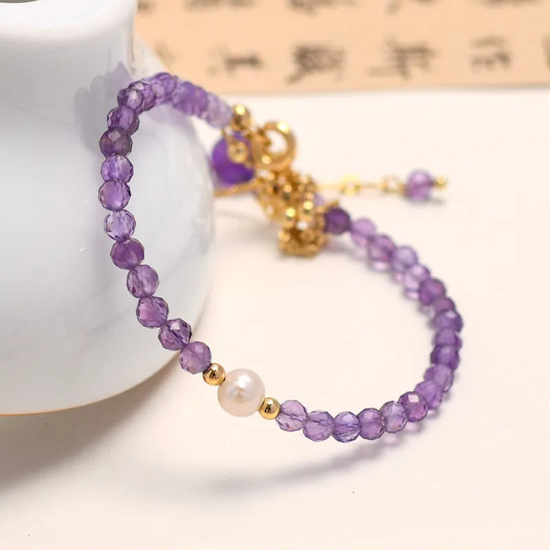Close-up of an amethyst coloured Chinese style bracelet for women, featuring electroplated diamond-shaped crystals.