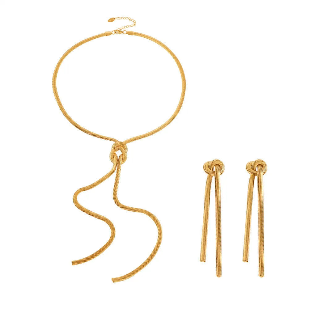 Gold long necklace with knotted tassel pendant and snake chain, shown with matching earrings.