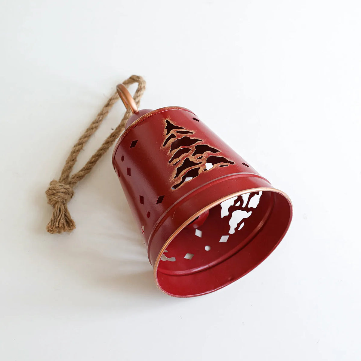Wrought iron Christmas bell ornament in red, green, and white with hanging loop on a white background