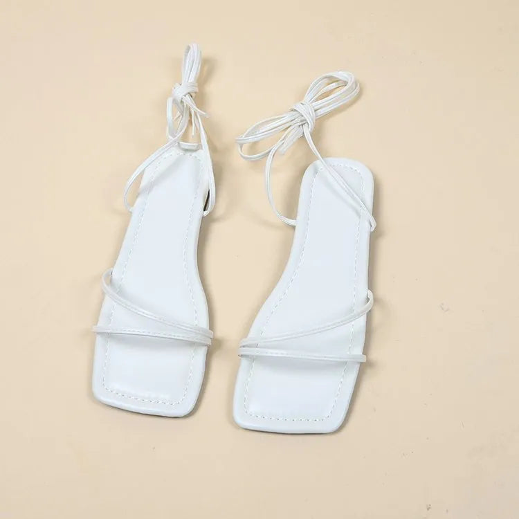 Women's flat sandals with ankle ring bandage cloth detail, square toe, and front lace-up straps in black.