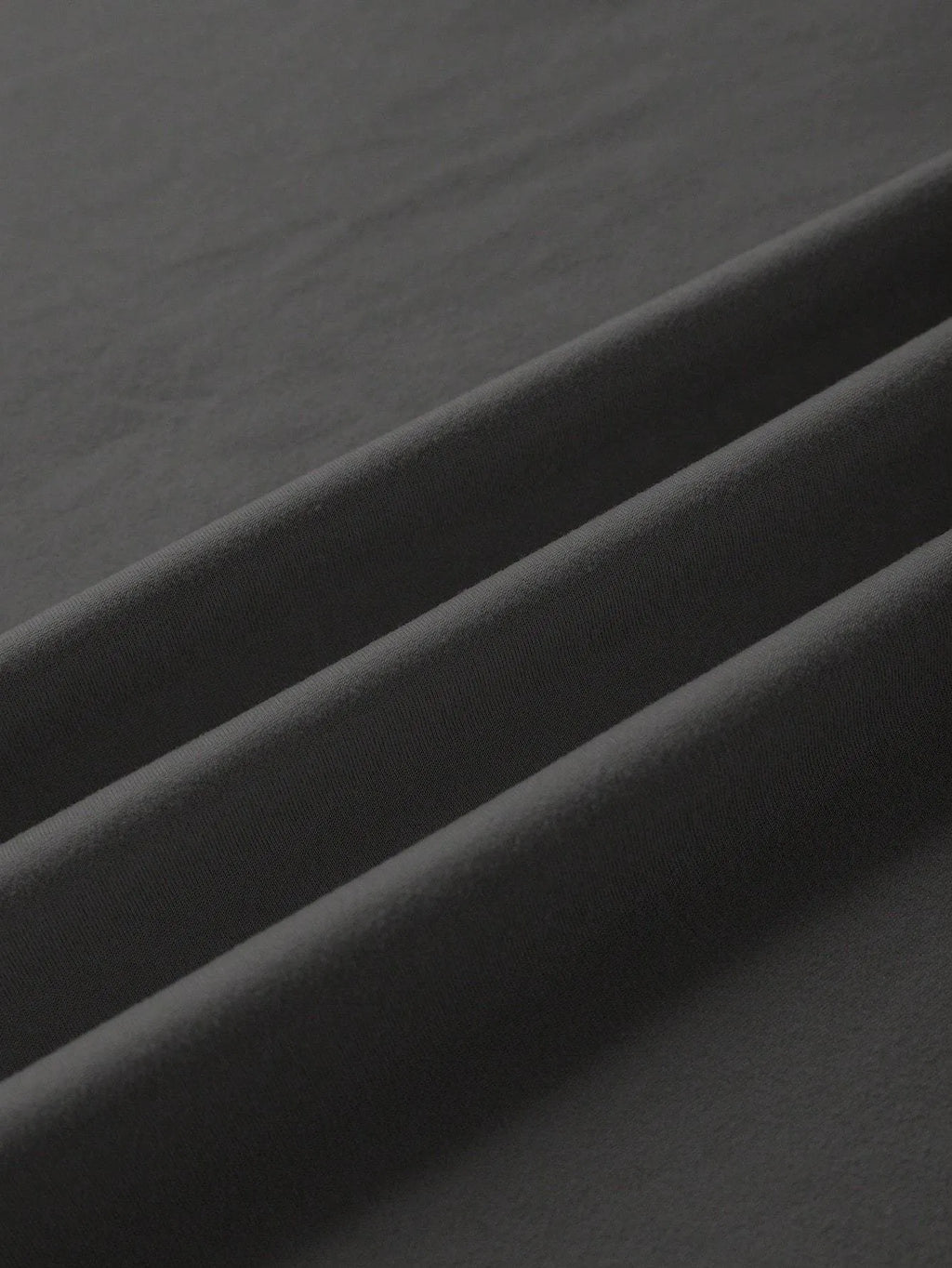 Loose short-sleeve cotton T-shirt on a hanger, showing round neckline, available in black, green, grey, and orange.