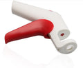 Red and white stainless steel manual cherry kernel remover pitter on a clean surface