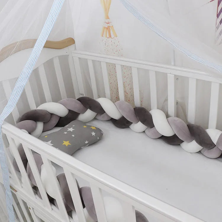 Baby cot bumper braid in spandex crystal velvet, shown in a light grey colour, wrapped around white crib rails.