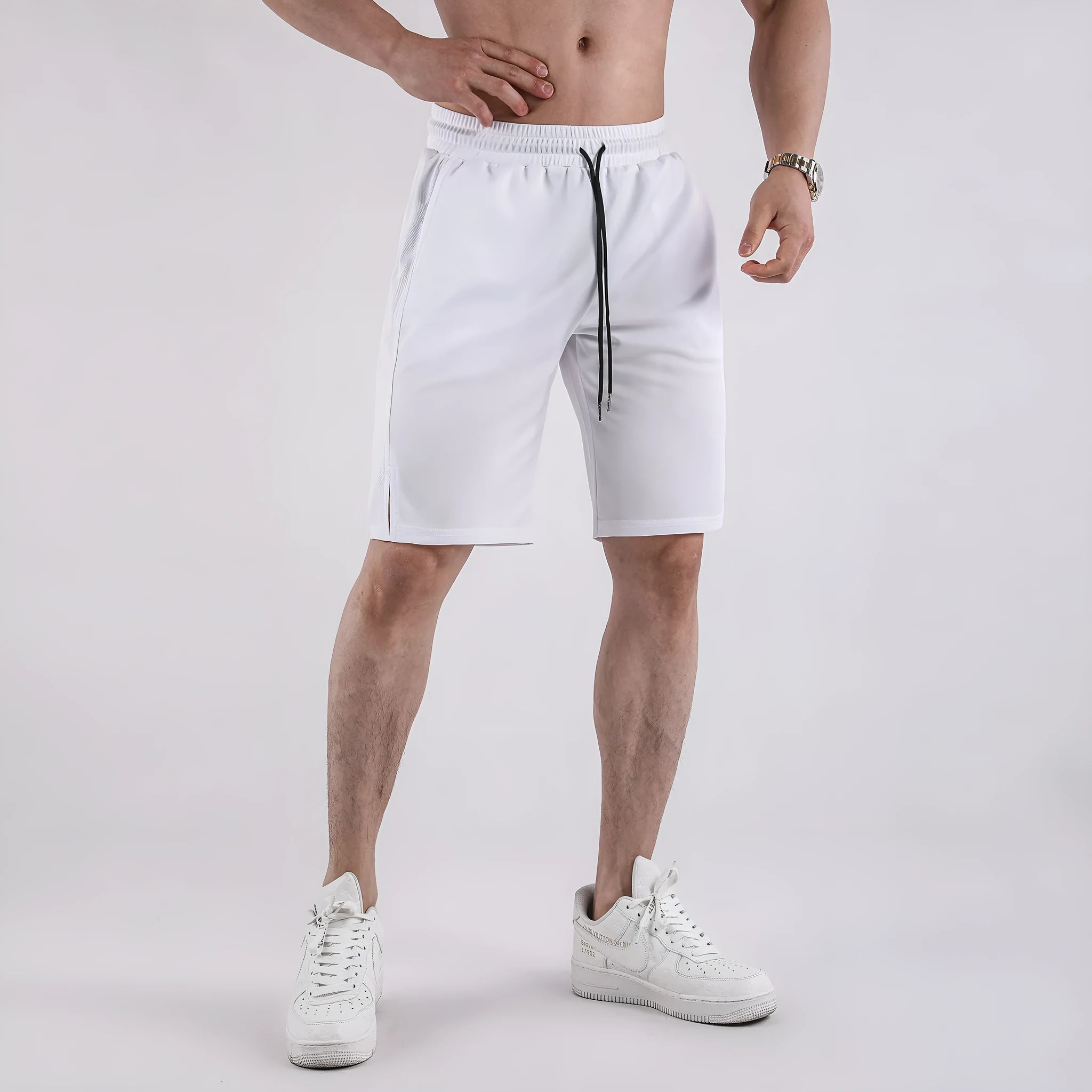 A man wearing loose-fitting black quick-dry mesh fitness shorts with an elastic waist.