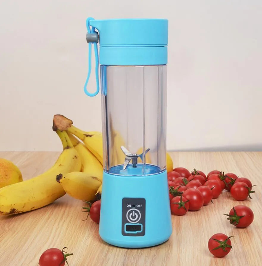 Pink mini USB electric fruit juicer with carrying rope on a kitchen countertop.