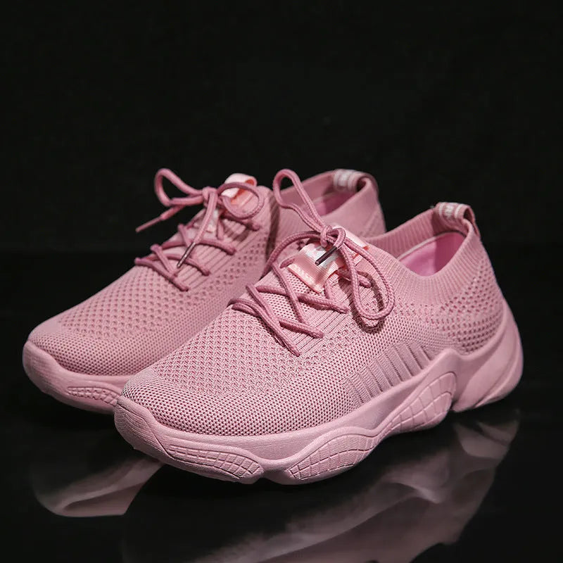 Women's white low-top woven sneakers with thick rubber sole and elastic front strap.