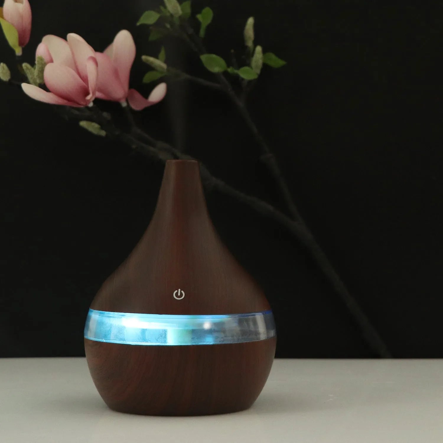 Columnar USB mini air purifier and humidifier in light wood grain finish on a desk.