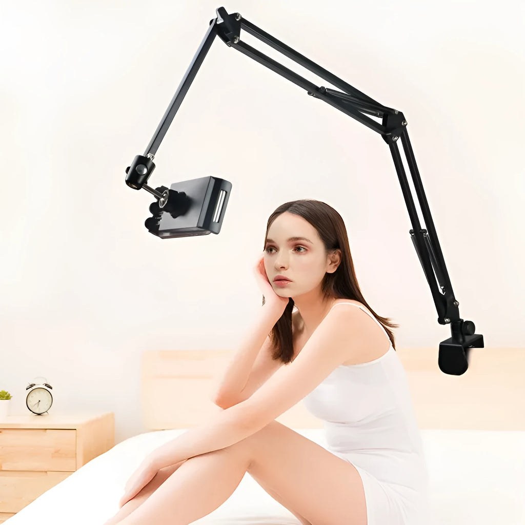 Black lazy mobile phone holder made of carbon steel and aluminium alloy placed on a bedside table.