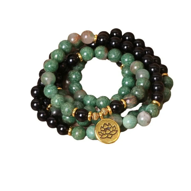 Green and black elastic beaded alloy bracelet on a wrist, showing its natural style and length.