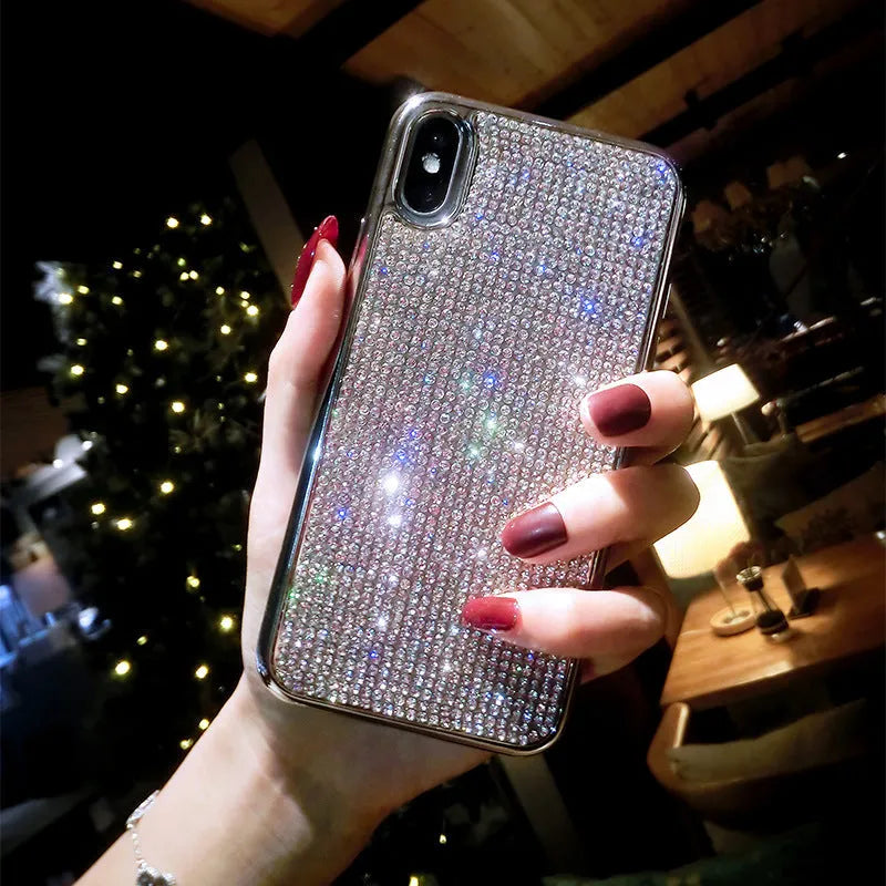 Silver silicone full diamond protective case for iPhone on a table.