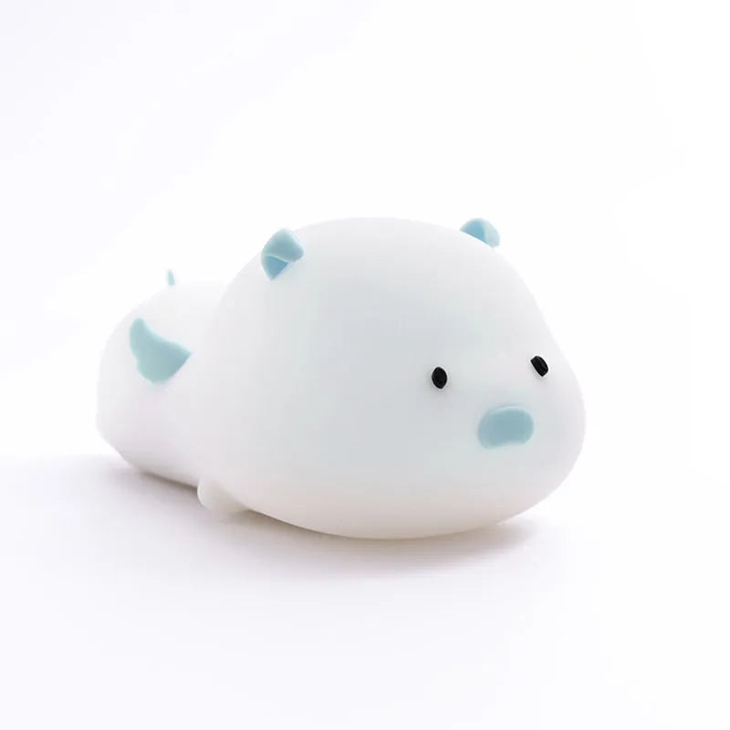 Blue silicone pig-shaped night light with sleeping design and USB charging port