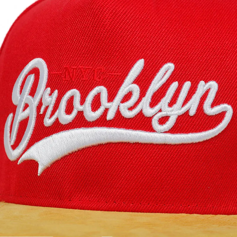 Adjustable cotton baseball cap with embroidered letters, dome top, short curved brim, in black and red for outdoor use