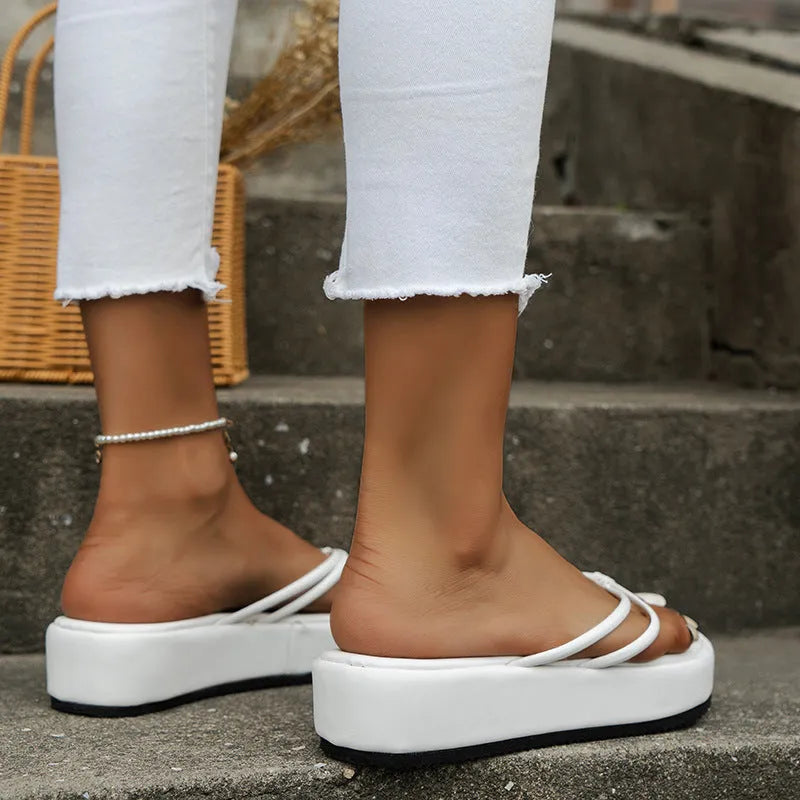 Thick-soled herringbone pattern flip-flops in multiple colours on a white background.