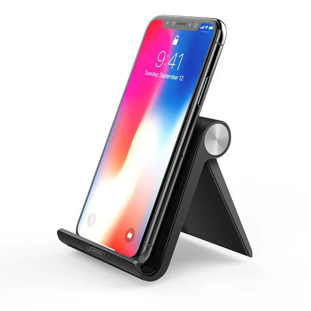 UGREEN Lazy Bracket portable phone holder in black on a desk, holding a mobile phone.