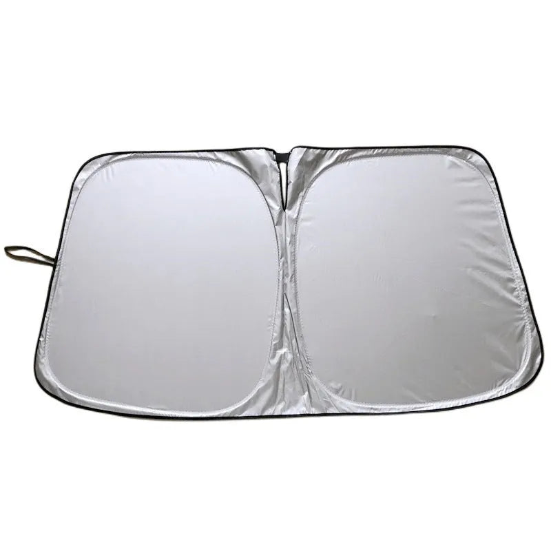 Titanium silver aluminium foil car windscreen sunshade unfolded on a dashboard.