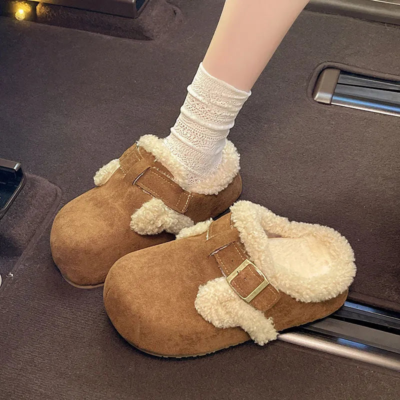 Baotou semi-drag fleece slippers in brown and camel with faux fur lining, closed toe, and rubber sole on a wooden floor