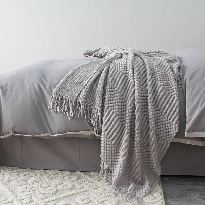 Small light grey polyester throw blanket folded, showing its rectangular 127cm by 170cm size.