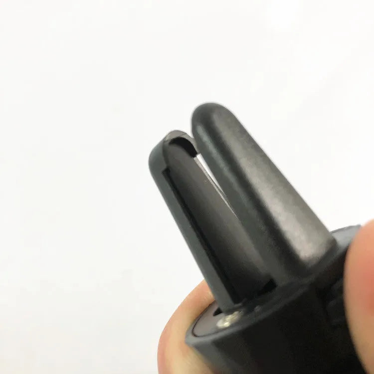 Black car phone holder mounted on vehicle air vent with phone in cradle