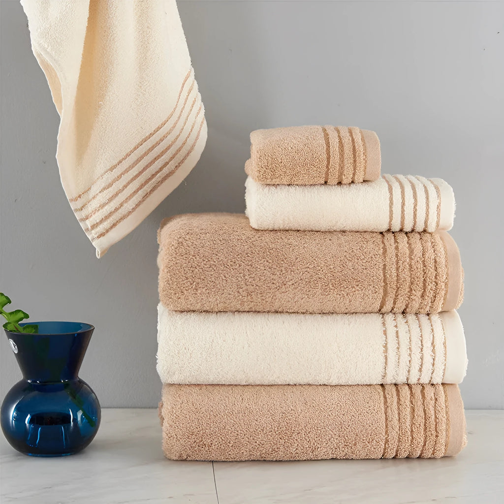 Set of three cotton towels in beige and brown colours, showing small, medium, and large sizes.
