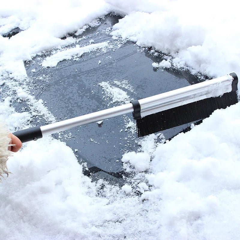 Silver retractable aluminum alloy car snow shovel extended to 65cm on a vehicle windscreen