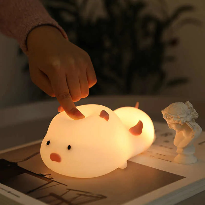 Blue silicone pig-shaped night light with sleeping design and USB charging port