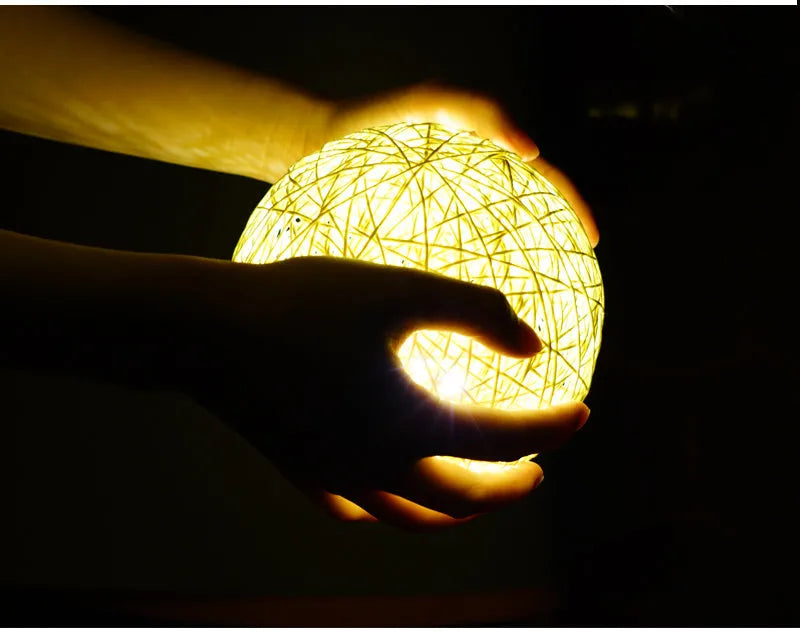Hand-woven beige lamb night light with starry sky projection on a bedside table