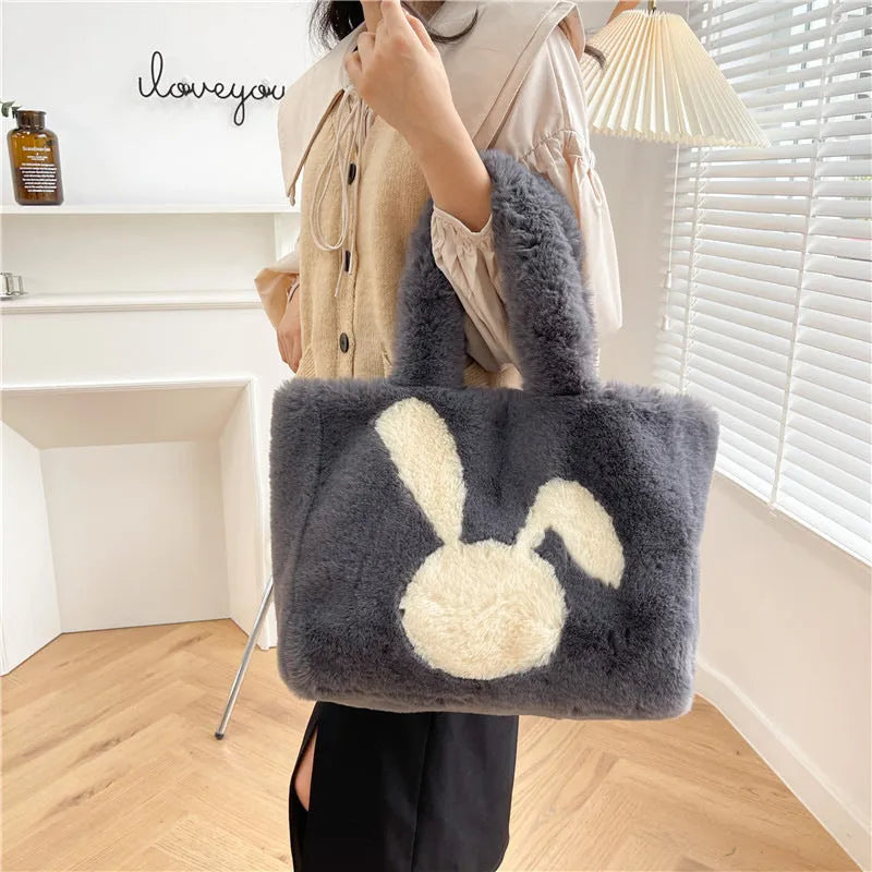 Soft beige plush tote bag with cartoon rabbit ears on the front, shown as a large capacity shoulder bag.
