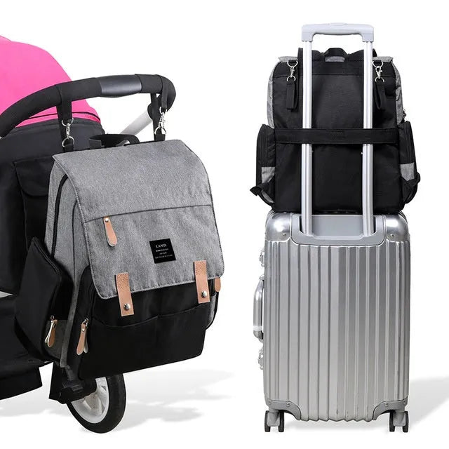 Land Mommy large oxford cloth diaper backpack in grey with a changing mat, shown open.