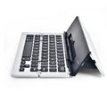 Slim aluminium folding wireless Bluetooth keyboard in four colours, expanded for typing on a flat surface