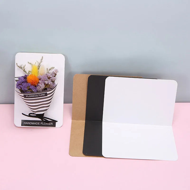 Pack of 100 blank folded kraft greeting cards in 10x15cm size, showing black, brown, and white colour options.