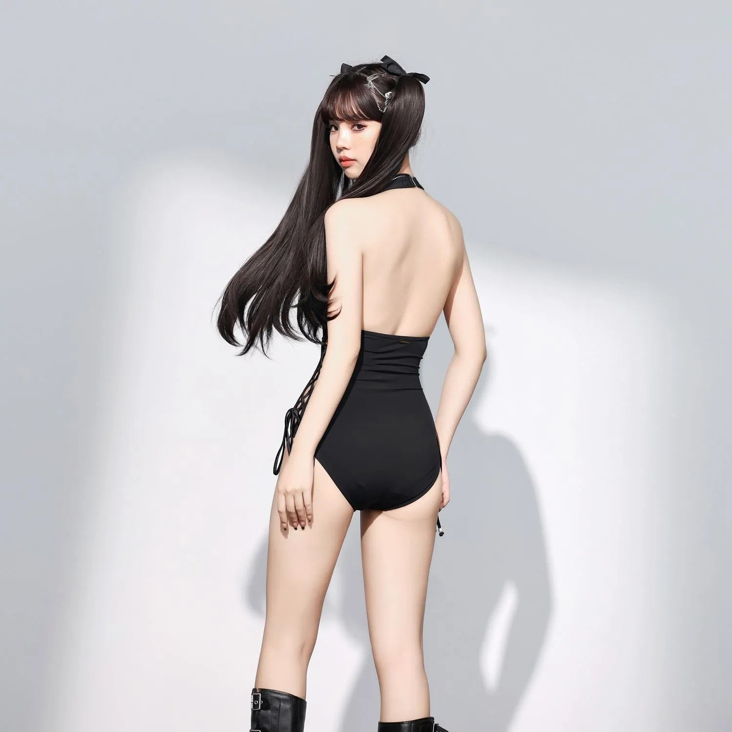 Black women's one-piece swimsuit with V-neckline and hollow strap design on mannequin