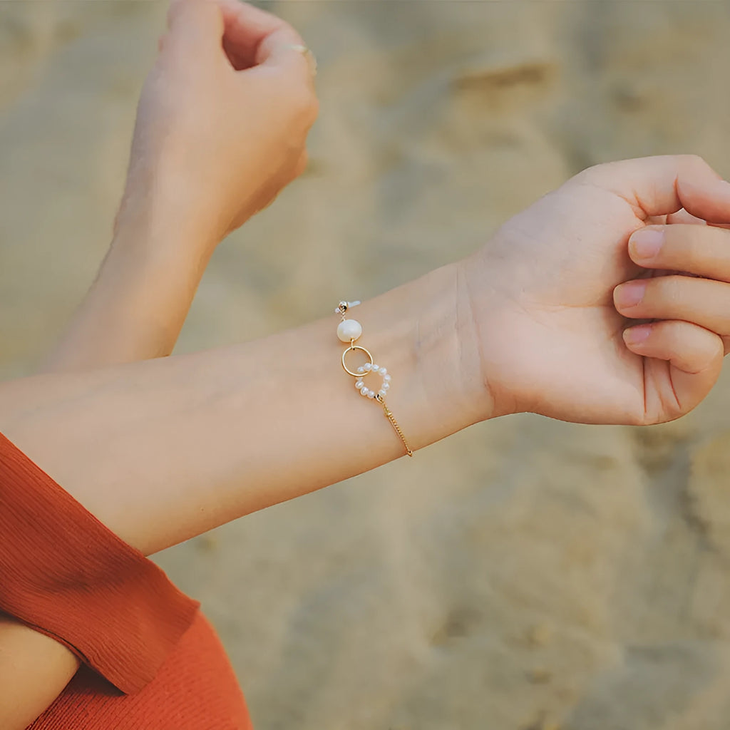 Women's adjustable natural pearl bracelet with gold-plated clasp on white background