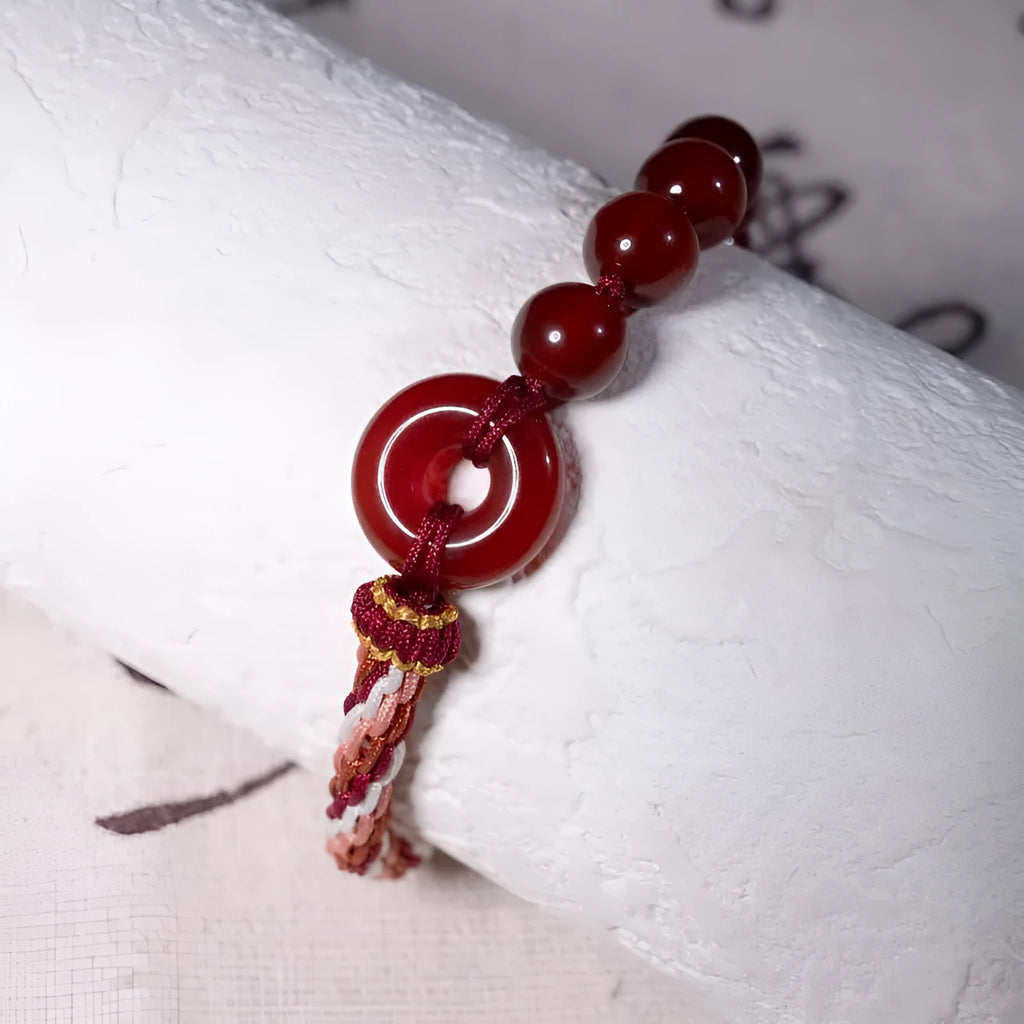 Red agate carrying strap bracelet with elk element on neutral background