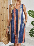 A woman wearing a striped colour block V-neck sleeveless midi dress in a casual setting.