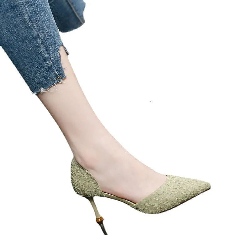 Women's black pointed high heel shoes with stiletto heel on light background