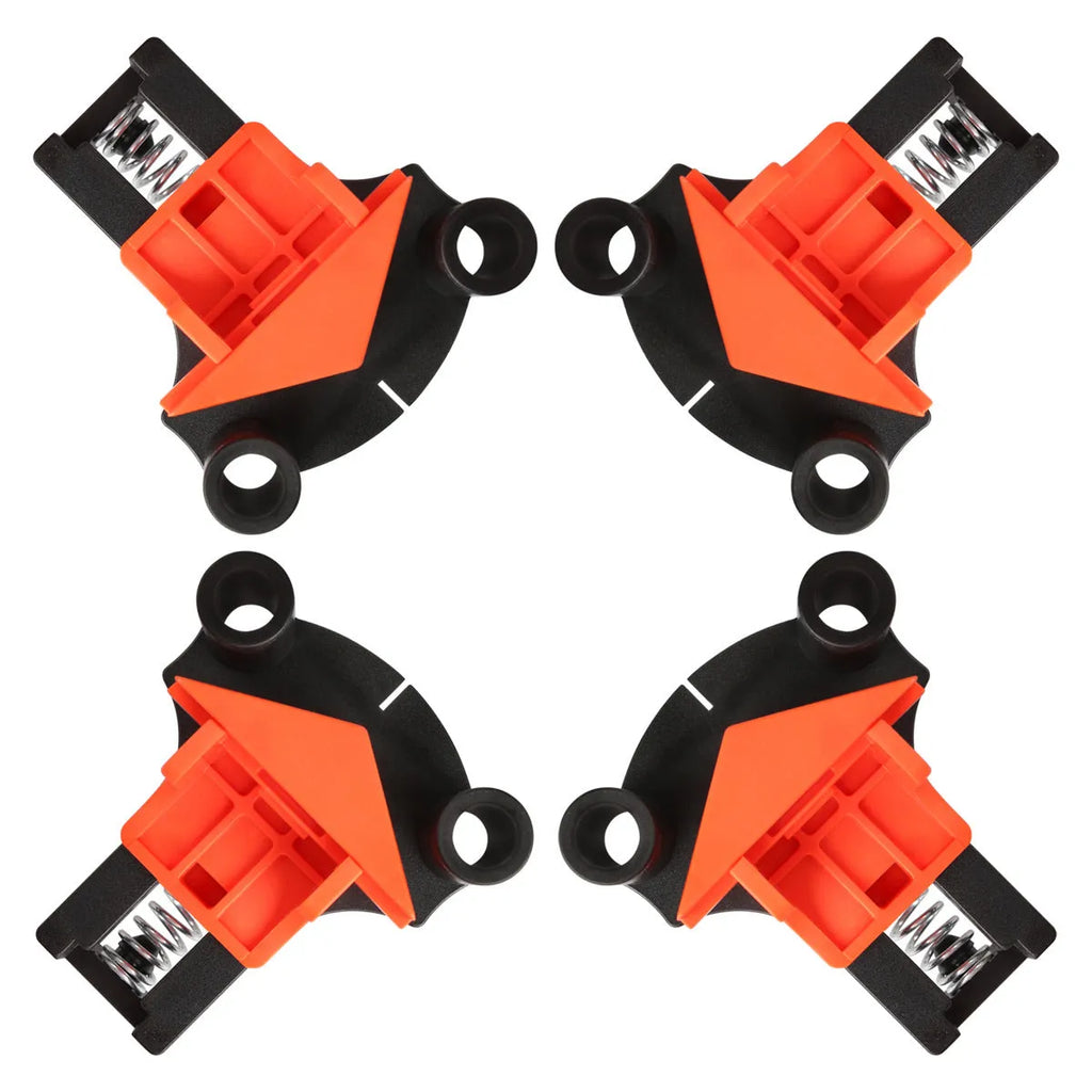 Set of four white plastic right angle clamps for picture frame assembly on a wooden surface.