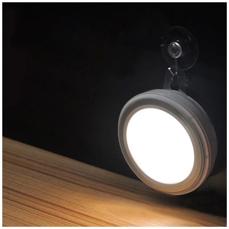 Compact round motion sensor LED light with 80mm diameter, shown in a wardrobe setting.