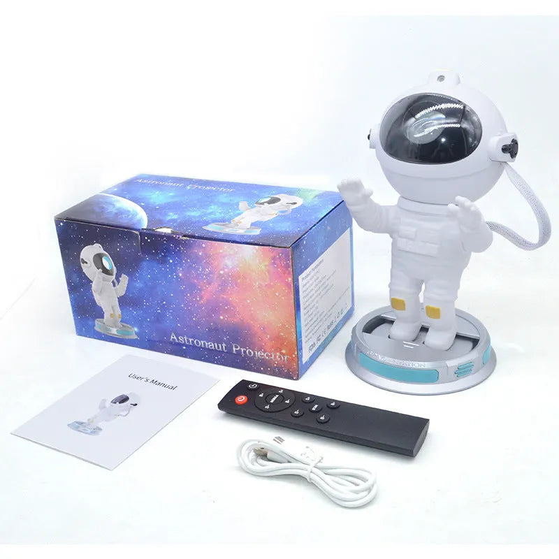 White Exit Astronaut Starlight Projection Lamp with USB cable and remote control on a table, projecting a blue starry light effect