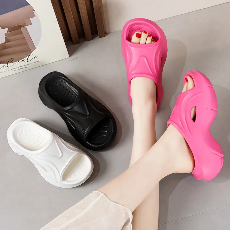 Women's thick-soled EVA slipper in rose red colour on a sandy beach background.