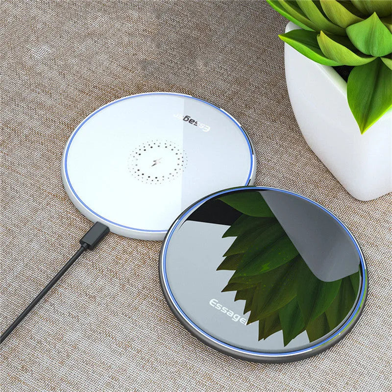 Black Qi wireless charging pad on a desk with blue LED light indicating active charging.