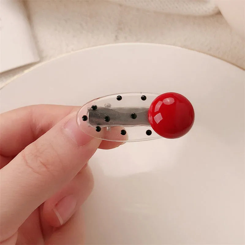 Red love heart-shaped plastic hair clip with retro dots and a willow leaf silhouette on a white background.